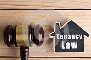 Real estate concept -auction gavel and little house with inscription Tenancy law photo