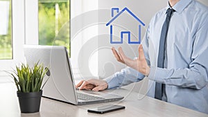 Real estate concept, businessman holding a house icon.House on Hand.Property insurance and security concept. Protecting gesture of