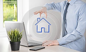 Real estate concept, businessman holding a house icon.House on Hand.Property insurance and security concept. Protecting gesture of