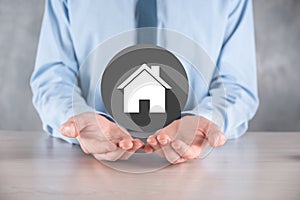 Real estate concept, businessman holding a house icon.House on Hand.Property insurance and security concept. Protecting gesture of