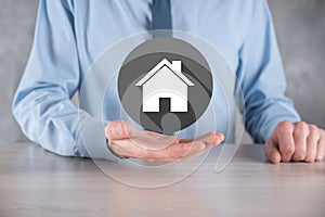 Real estate concept, businessman holding a house icon.House on Hand.Property insurance and security concept. Protecting gesture of