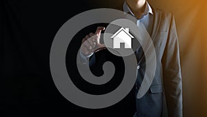 Real estate concept, businessman holding a house icon.House on Hand.Property insurance and security concept. Protecting gesture of