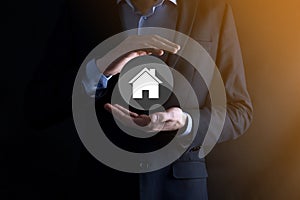 Real estate concept, businessman holding a house icon.House on Hand.Property insurance and security concept. Protecting gesture of