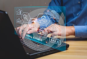 Real estate concept, Businessman or home broker with virtual hologram property value on laptop screen.