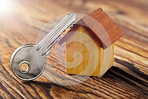 Real estate concept with house and key on wooden background. Idea for real estate concept, personal property an