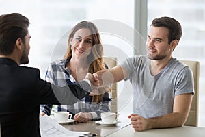 Real estate deal concept, happy couple customers handshaking realtor photo