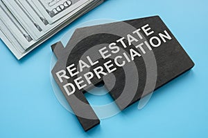 Real estate depreciation sign on the model of house. photo