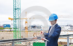 Real estate developer in helmet. New office construction. Confident business men or architect in front of office