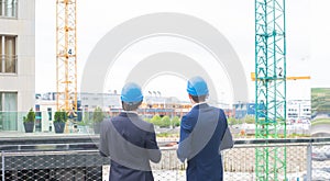 Real estate developers in helmets. New office construction. Confident business men and architect talking in front of