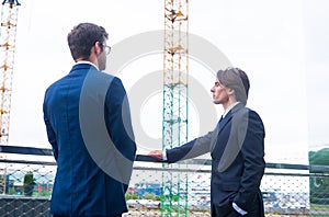 Real estate developers in helmets. New office construction. Confident business men and architect talking in front of