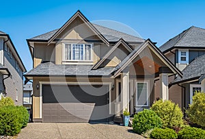 Real Estate Exterior Front House in a summer.Big custom made luxury house with nicely landscaped front yard and driveway