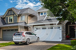 Real Estate Exterior Front House in a summer.Big custom made luxury house with nicely landscaped front yard and driveway