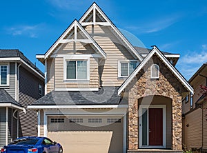 Real Estate Exterior Front House on a sunny day. Big custom made luxury house with nicely driveway to garage in summer