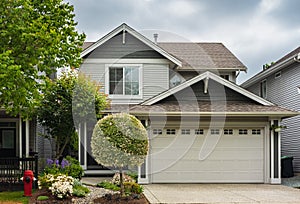 Real Estate Exterior Front House on a sunny day. Big custom made luxury house with nicely landscaped front yard