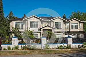 Real Estate Exterior Front House on a sunny day. Big custom made luxury house with nicely landscaped front yard