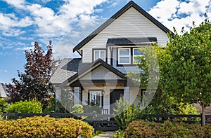 Real Estate Exterior Front House on a sunny day.Big custom made luxury house with nicely landscaped front yard in summer