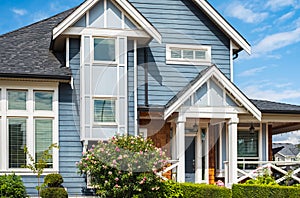 Real Estate Exterior Front House on a sunny day.Big custom made luxury house with nicely landscaped front yard in summer