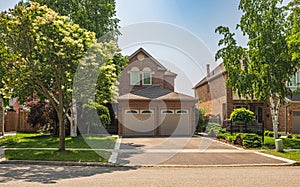 Real Estate Exterior Front House on a sunny day. Big custom made luxury houses with nicely landscaped front yard
