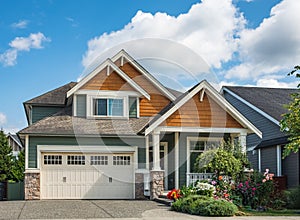 Real Estate Exterior Front House on a sunny day. Big luxury house with nicely landscaped front yard, driveway to garage