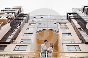 Real estate and family concept. Young couple on front of new big modern house their new home