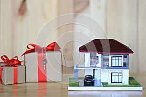 Real estate and Gift new home concept,Model house and Gift box on wooder background