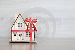 Real estate and Gift new home concept,Model house with Red ribbon on white background