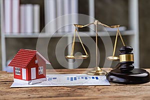 Real Estate Law Concepts Judge hammer and house model on the table, golden hammer and scales, small house