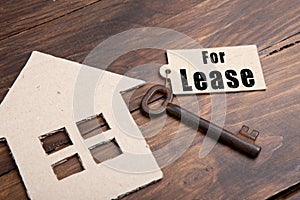 real estate lease concept - old key with tag and cardboard house