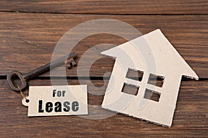 real estate lease concept - old key with tag and cardboard house