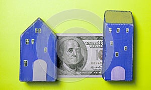 Real estate and money. Wooden toy house and one hundred dollar. Savings for home construction, mortgage, rental housing concept