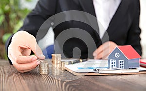 Real estate practitioners stack coins and tables on the small house model and related documents