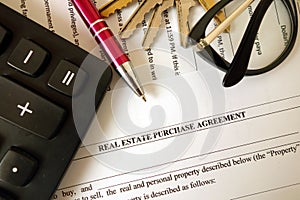 Real estate purchase agreement for filling with pen calculator keys and glasses