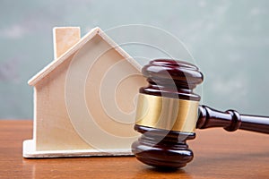 Real estate sale auction concept - gavel and house model on the wooden table