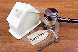 Real estate sale auction concept - gavel and house model on the wooden table