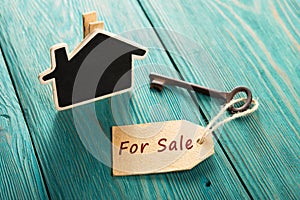 Real estate sale concept - old key with tag `For sale`