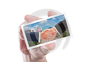 Real estate sale handshake on paper card