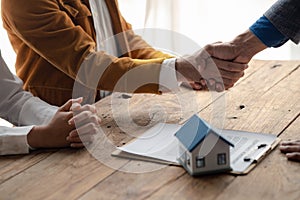 Real estate sales agents shake hands with customers of housing projects, explaining and presenting information about homes and