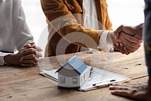 Real estate sales agents shake hands with customers of housing projects, explaining and presenting information about homes and