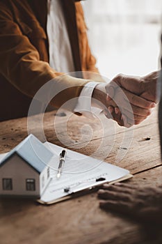 Real estate sales agents shake hands with customers of housing projects, explaining and presenting information about homes and