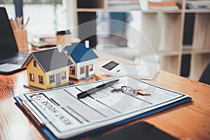 Real estate sales documents and model homes are placed on tables inside real estate sales offices to prepare prospective buyers to