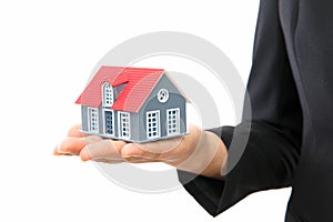 Real estate salesmen hold small house model in front of white background