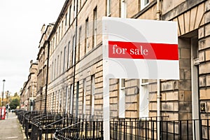 Real estate sign in front of a house on sale