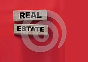Real estate text on wooden blocks on red. Rent, buy property concept