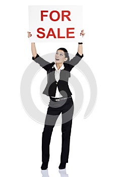 Real estate woman holding for sale sign