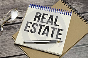 real estate words on the white notebook on wooden background