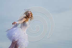 Real fairy from magical stories. Concept of innocent child. A beautiful teen with blonde curly hair and a bow and arrow