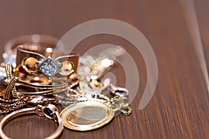 Real gold rings with diamonds, gems, neckless on dark cracked wood background