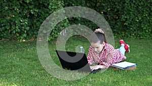 Real happiness. happy girl sitting on green grass with laptop. Run. the child is playing a computer game. back to school