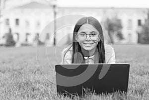 Real happiness. happy girl sitting on green grass with laptop. Start up. child playing computer game. back to school