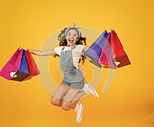 Real happiness. happy small girl after successful shopping. energetic child jump with heavy bags. holiday gifts in
